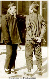 two chinese men converse in Chinatown street